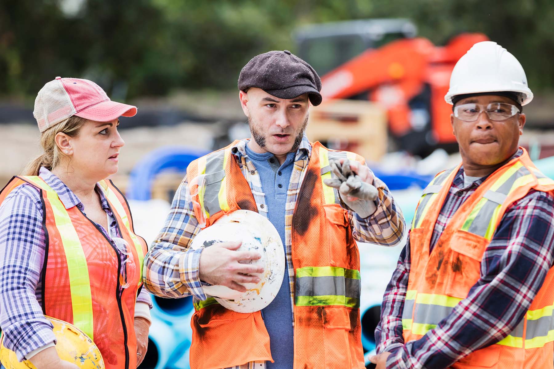 Construction workers with diverse backgrounds hold a meeting at a construction site.