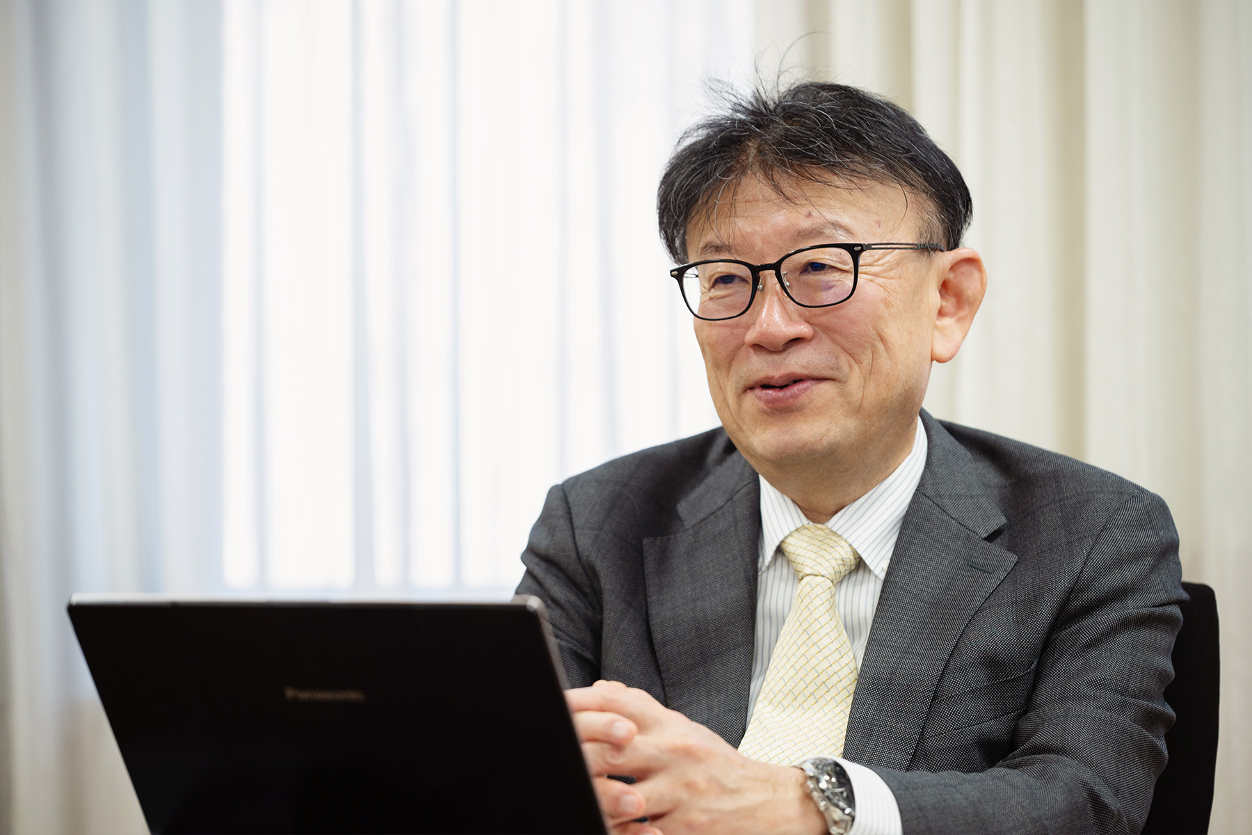 Prof. Noguchi sits behind a computer during the discussion in a conference room at Hokkaido University.