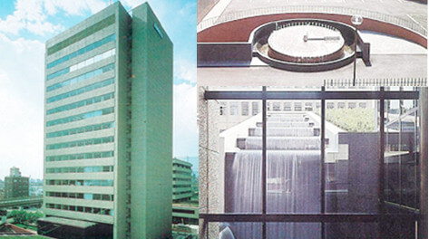 The new headquarters building completed in 1977, the clock fountain and the man-made waterfall using greywater on the West side of the building